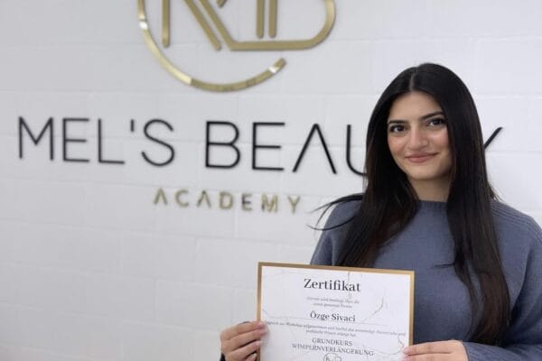 Absolventin einer Wimpernverlängerungs-Schulung hält ihr Zertifikat bei Mel’s Beauty & Academy in 5212 Hausen AG.